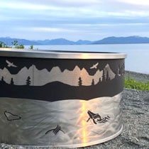 Metal fire ring with Alaskan view in the background.